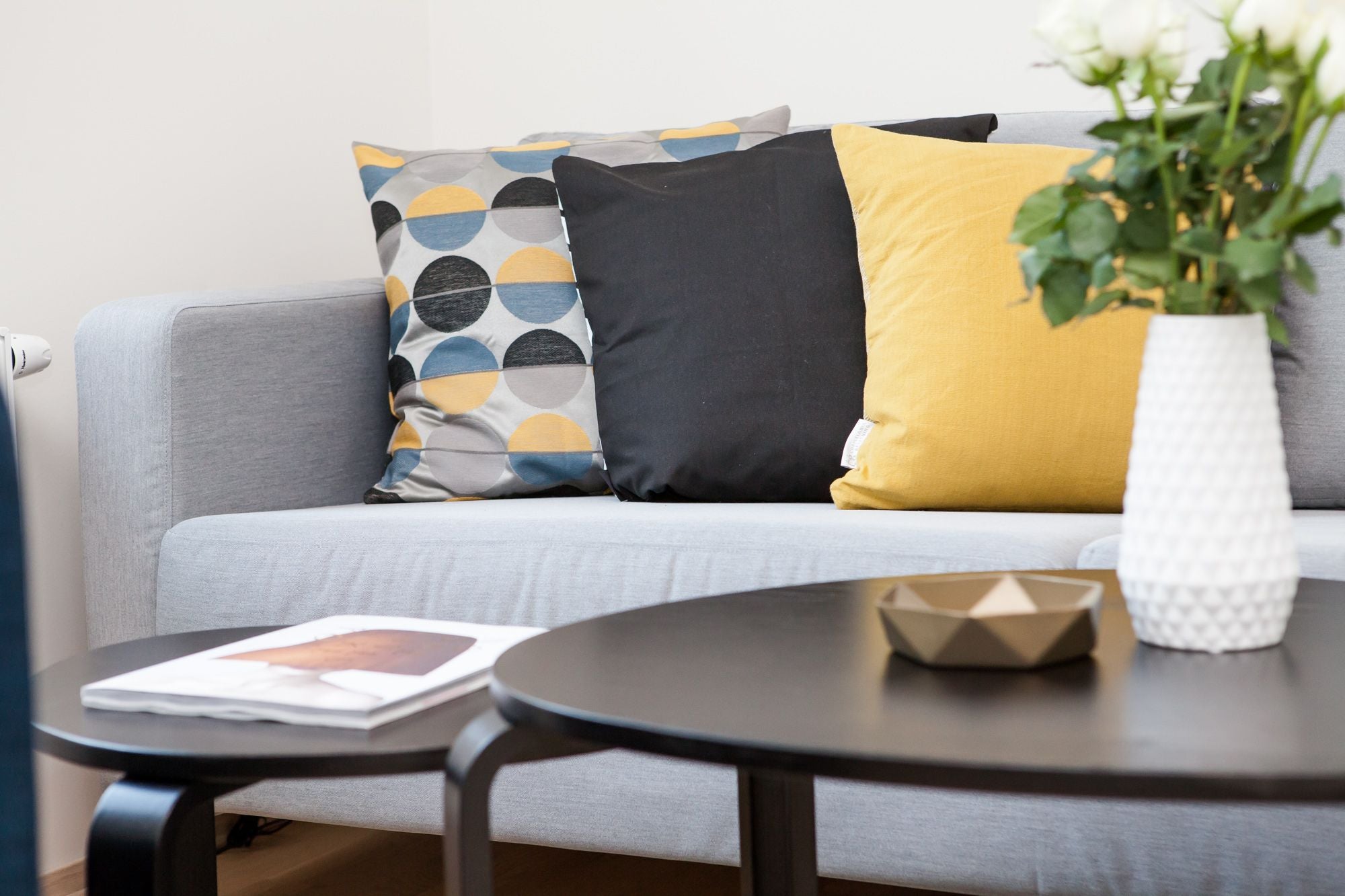 living room with grey sofa with throw pillows and coffee table