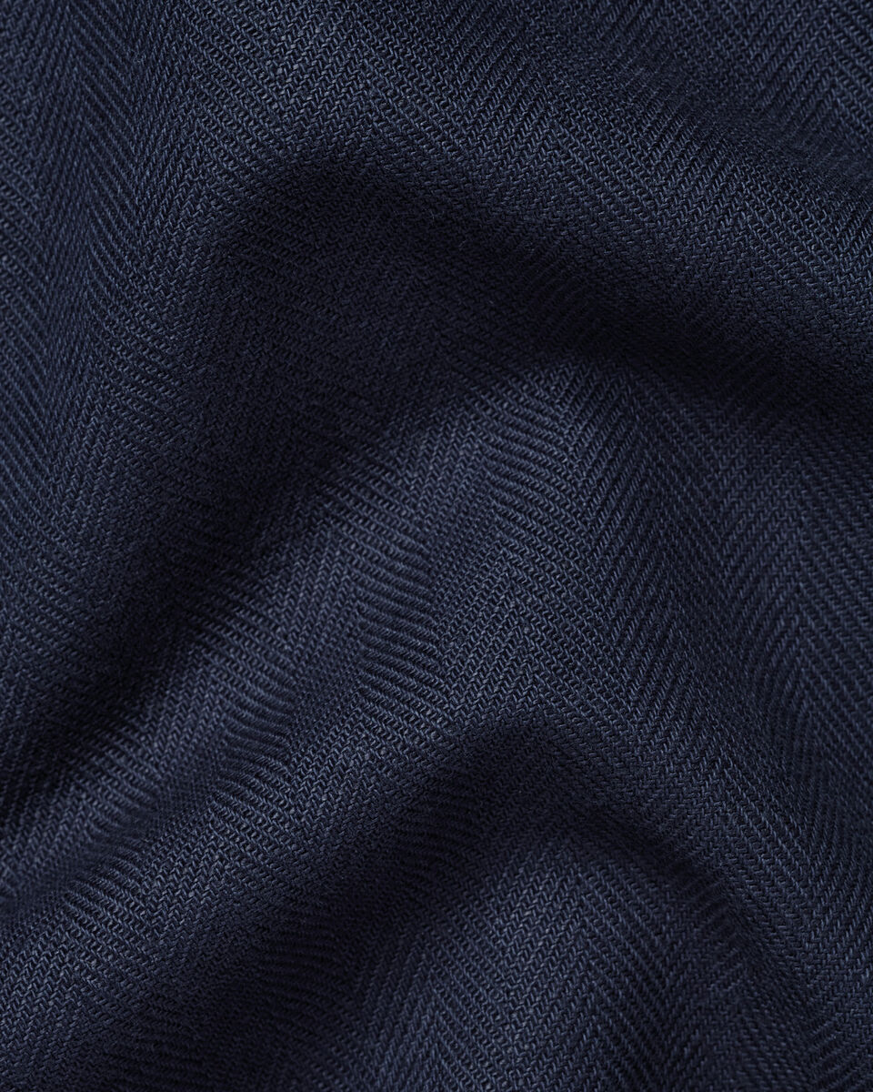 A close-up of dark navy blue fabric with a subtle herringbone texture and soft folds.