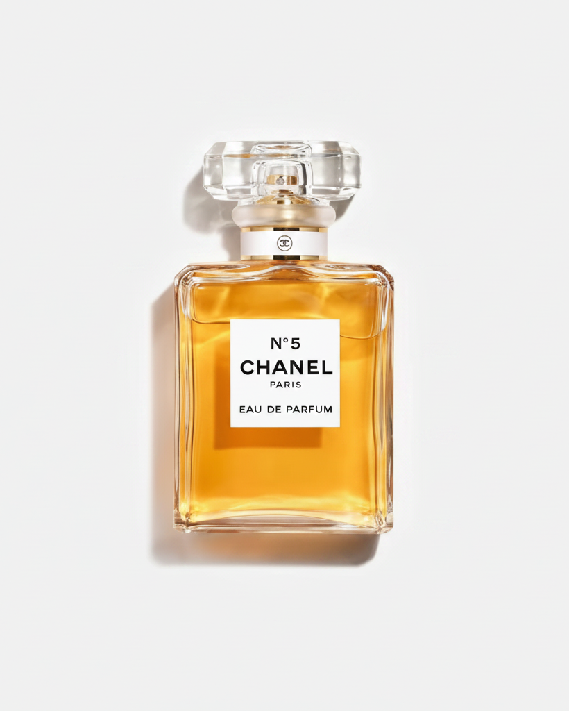 Chanel No. 5 Eau de Parfum bottle with a clear glass cap and a white label, filled with golden-amber liquid, centered on a white background.