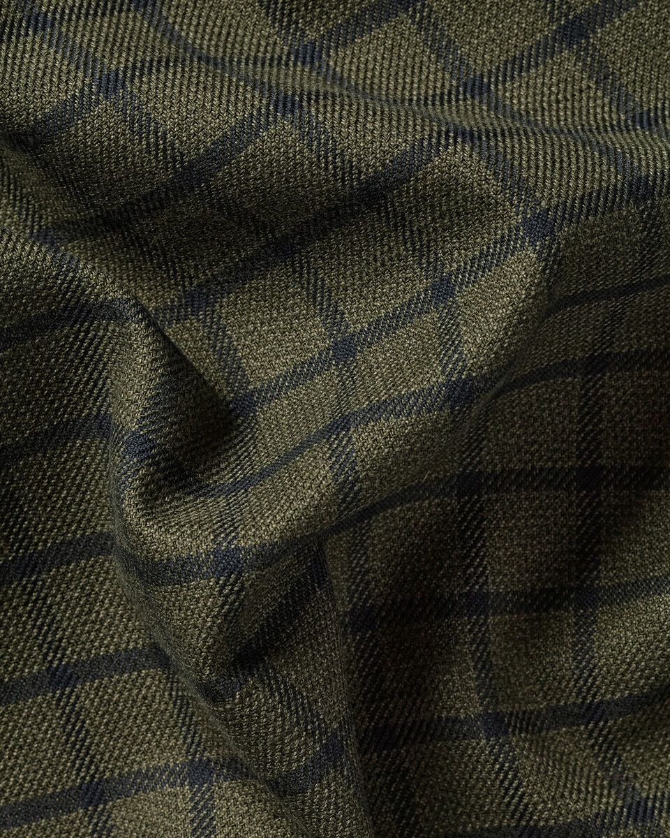 A close-up of a textured woven fabric with a dark olive green base and a subtle navy blue windowpane plaid pattern.
