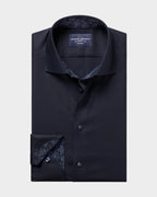 A folded charcoal gray dress shirt with a patterned inner collar and cuff, displayed on a solid beige background. The brand label reads 'CHARLES TERREYROT'.