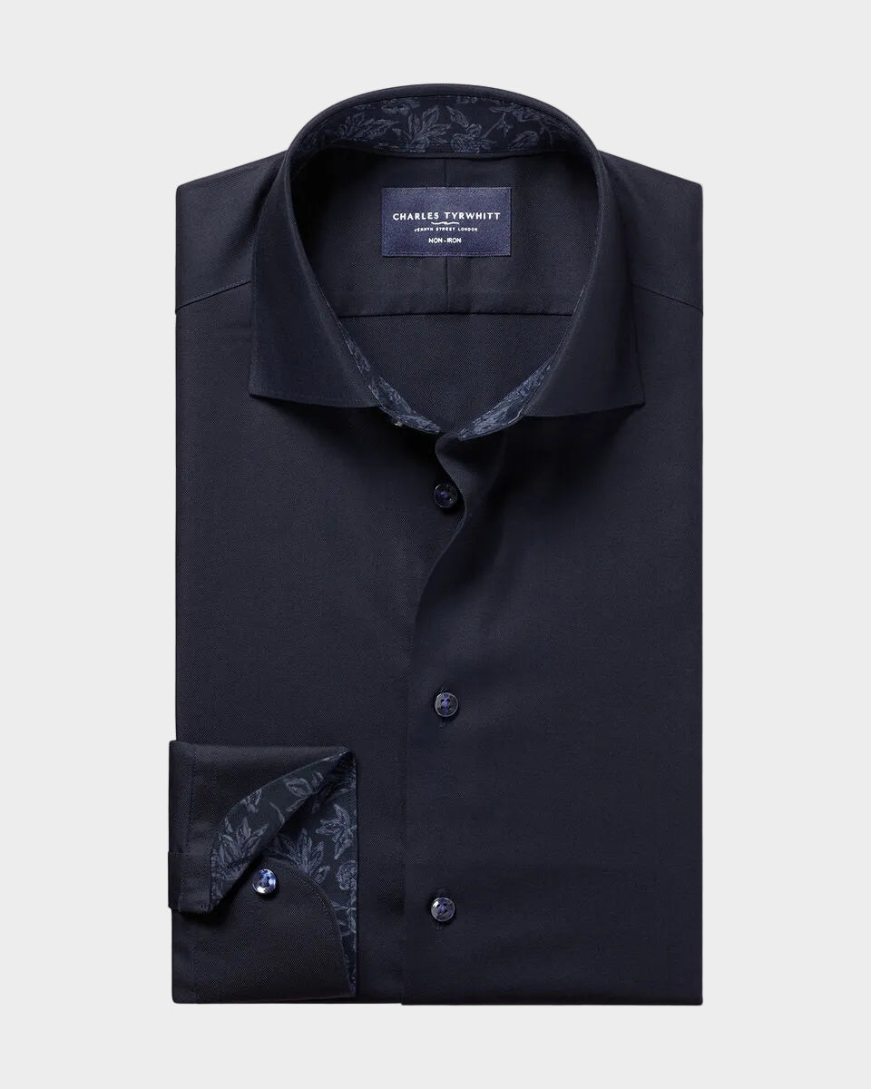 A folded charcoal gray dress shirt with a patterned inner collar and cuff, displayed on a solid beige background. The brand label reads 'CHARLES TERREYROT'.