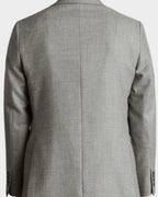 Man wearing a gray checkered suit jacket on a plain background