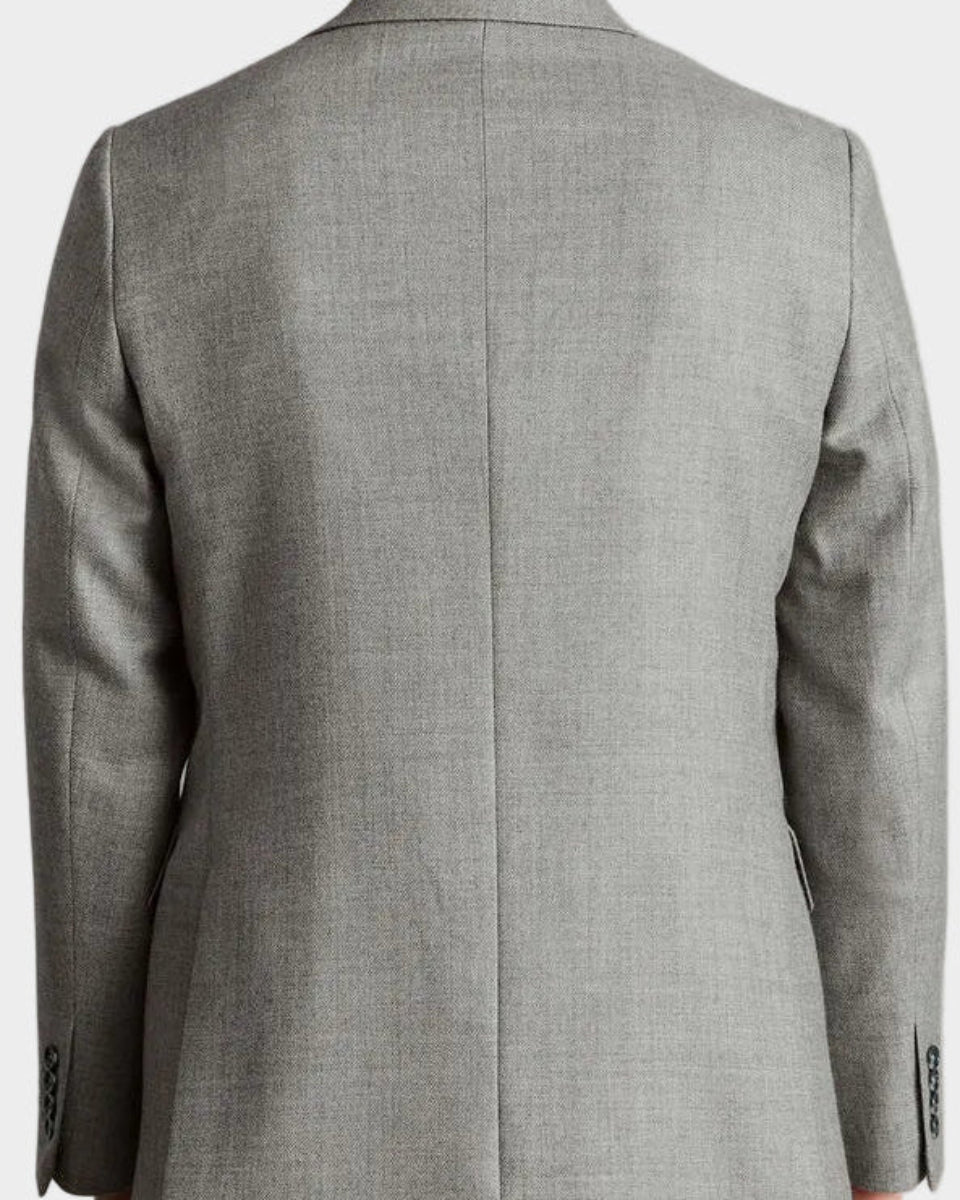 Man wearing a gray checkered suit jacket on a plain background
