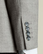 Close-up of a gray textured blazer with three buttons on a neutral background
