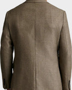 Man wearing a brown blazer against a beige background