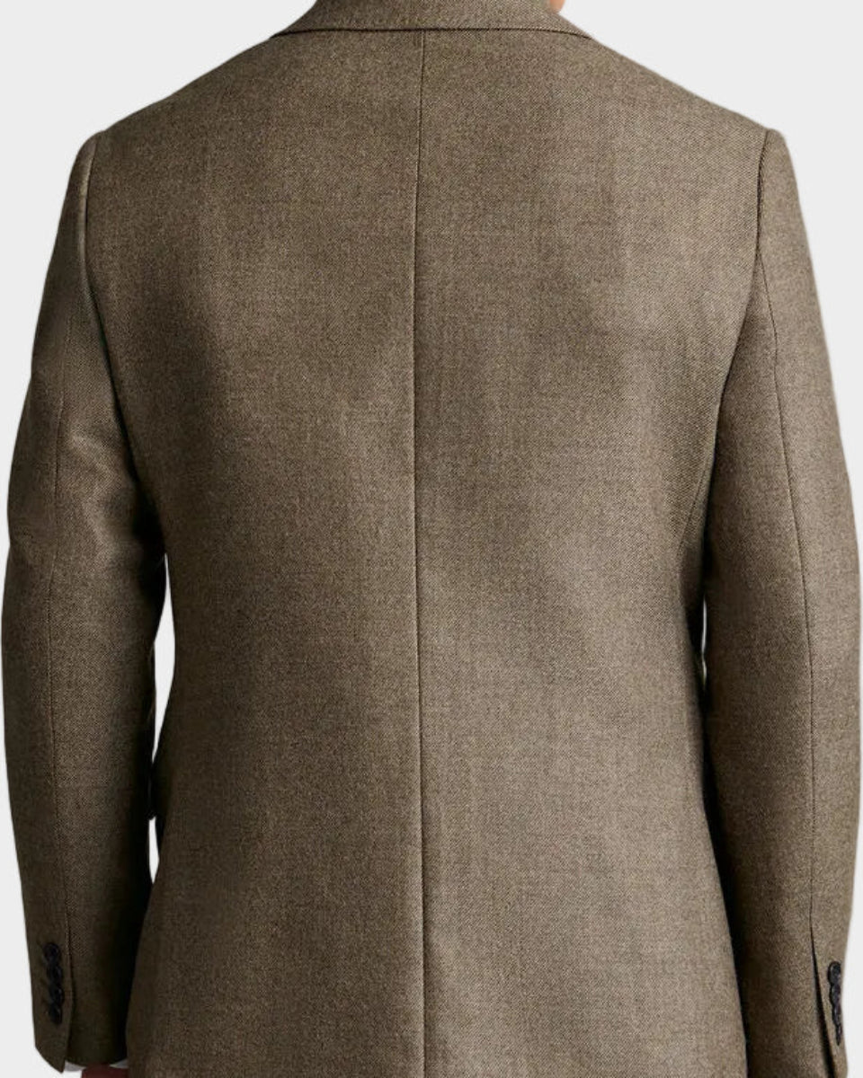 Man wearing a brown blazer against a beige background