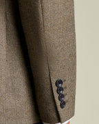 Brown textured blazer with three buttons on a neutral background