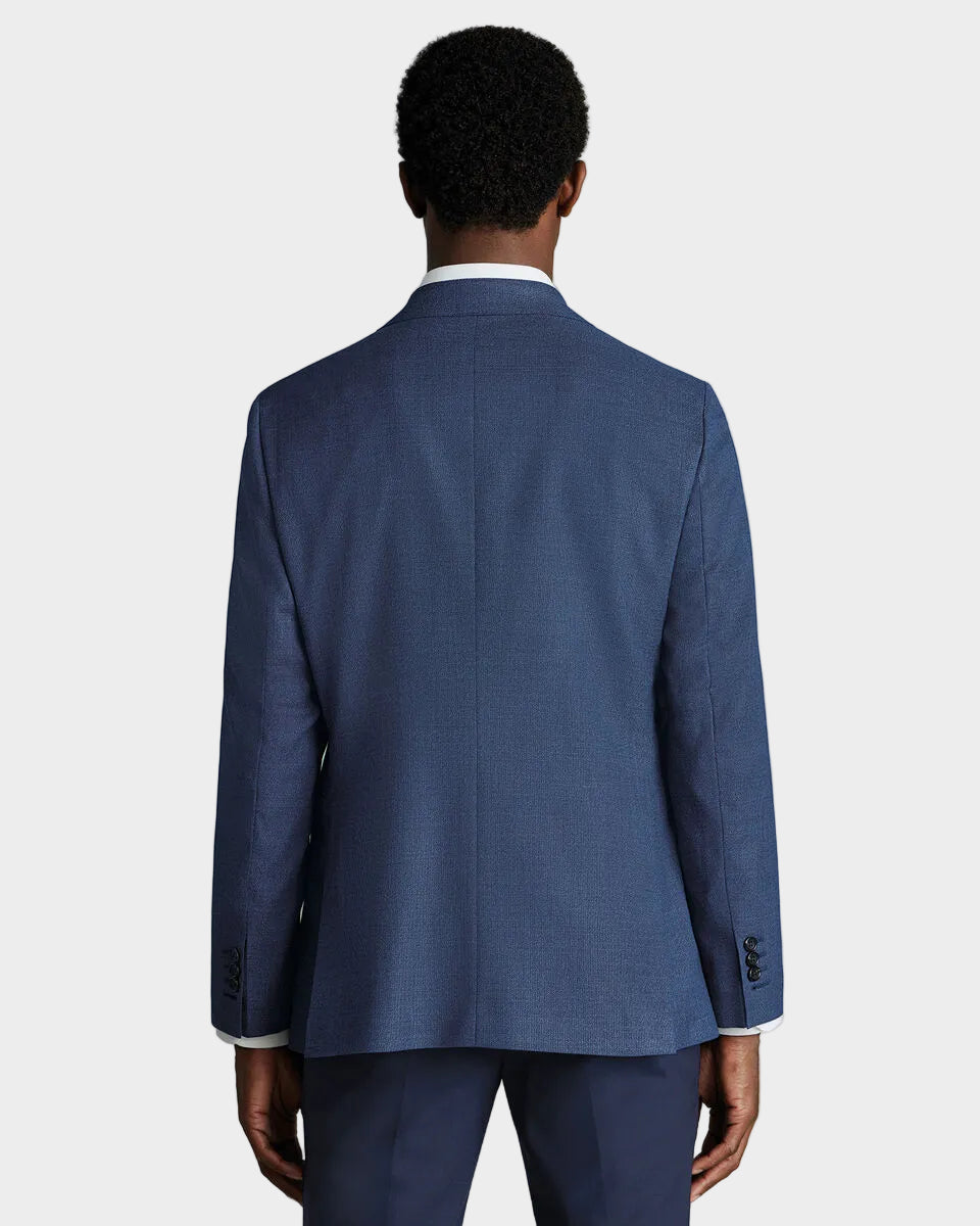 Person wearing a blue suit jacket on a beige background
