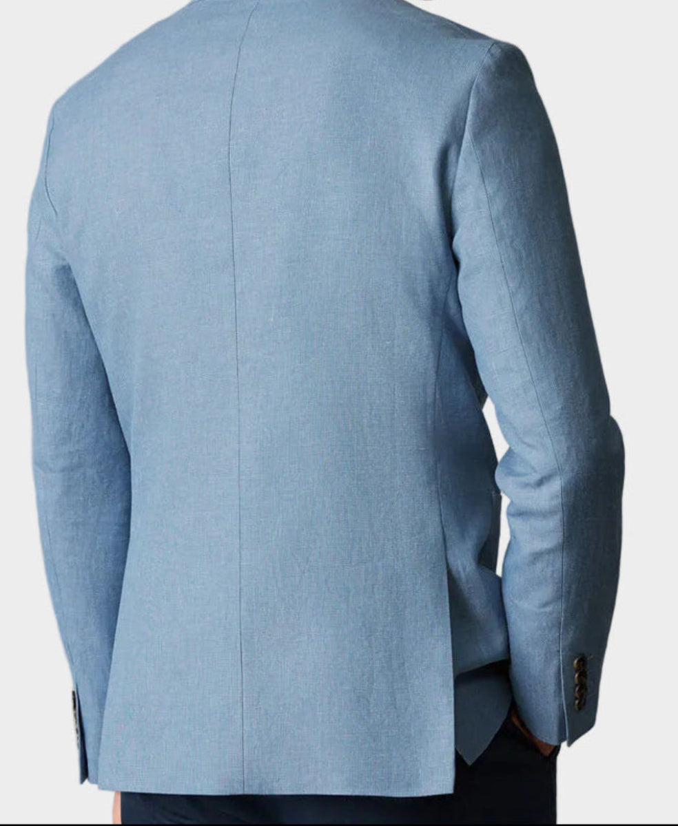 Man wearing a light blue blazer against a neutral background