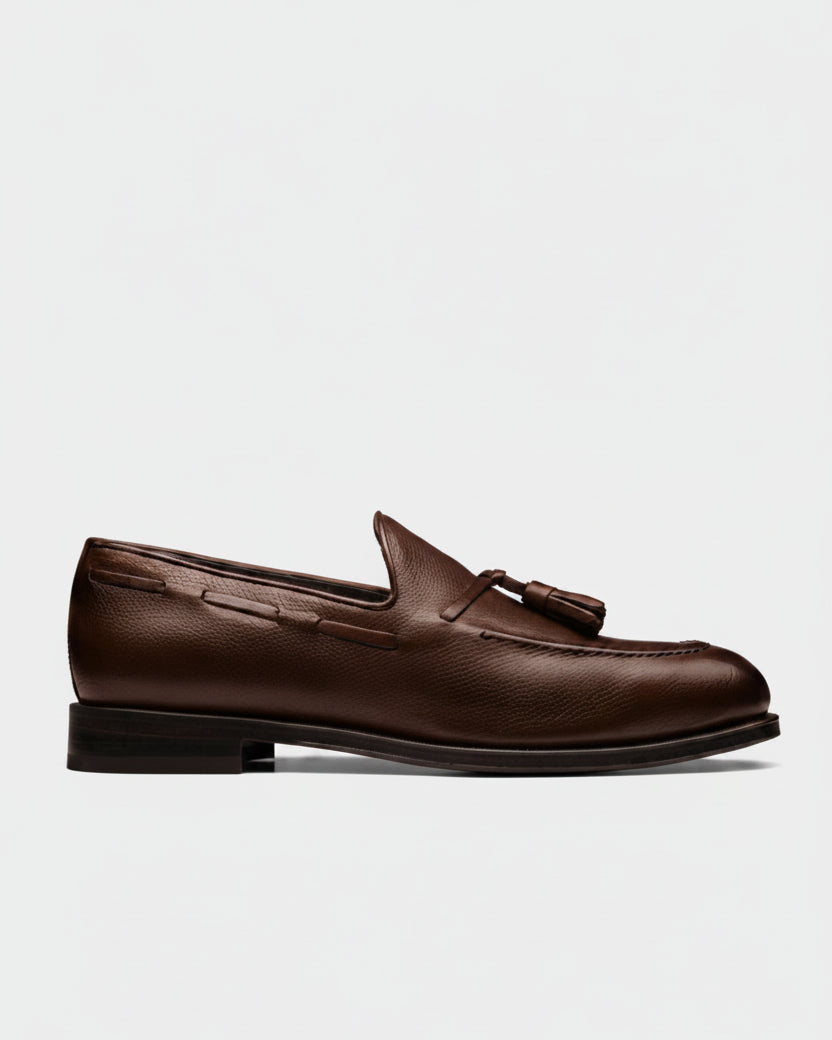 Brown leather loafer with tassel on a beige background