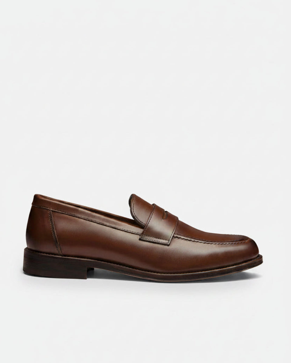 Brown leather loafer on a beige background