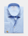 A folded light blue and white striped dress shirt with a pointed collar, button front, and a gold cufflink, shown on a light gray background. The inner neck label reads Martin & Co.