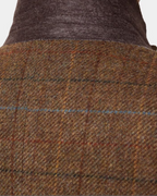 Close-up of a brown and beige plaid tweed jacket with a dark brown corduroy-like collar, showing the fabric texture and weave.