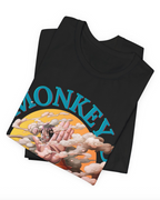A folded black t-shirt featuring a graphic print of Monkey D. Luffy from One Piece, with his face covered in clouds and the word 'MONKEY' printed in blue arched text across the chest, displayed on a clean white background.