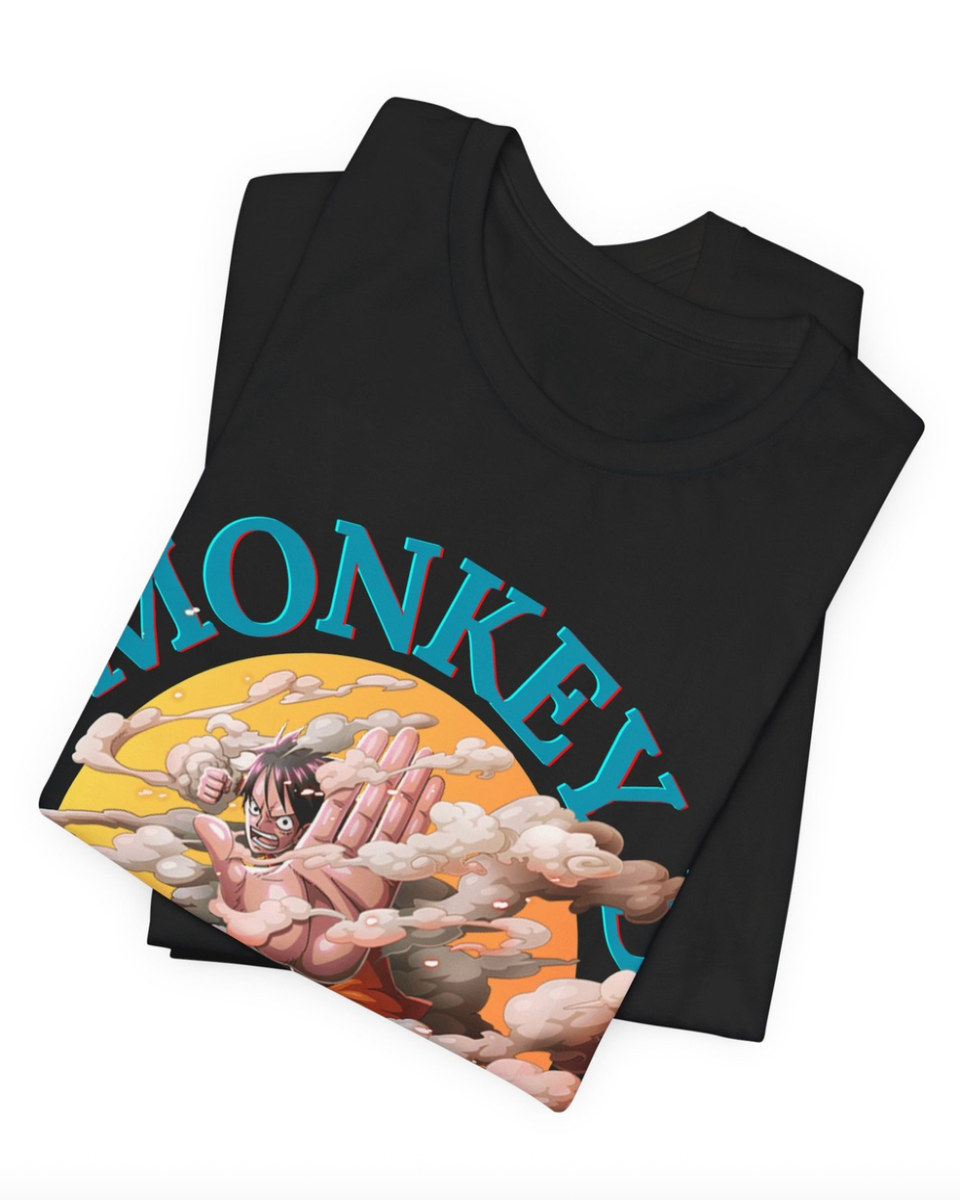 A folded black t-shirt featuring a graphic print of Monkey D. Luffy from One Piece, with his face covered in clouds and the word 'MONKEY' printed in blue arched text across the chest, displayed on a clean white background.