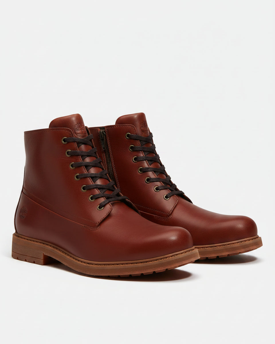 A pair of men's leather lace-up ankle boots in a rich reddish-brown color, featuring black laces, a side zipper, and a rugged brown sole, shown against a light gray background.
