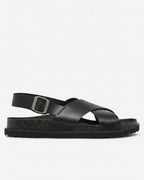 Black sandal with a buckle on a light gray background