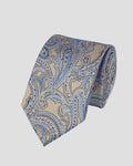 A rolled necktie featuring a detailed paisley pattern in shades of blue, beige, and gold, set against a solid light beige background.